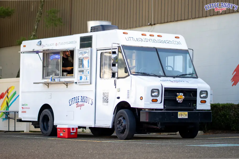 Little Andy's smash burger truck parked in Asbury Park NJ with the service window open and a cook at the griddle